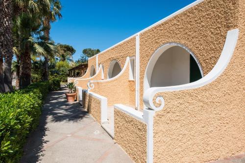 a wall with arches on it next to a sidewalk at Hotel Parco Delle Agavi in Ischia