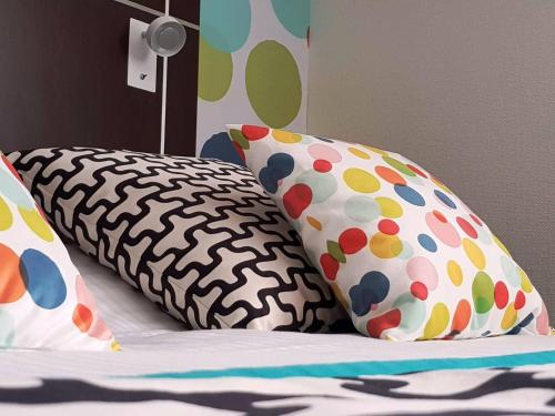 a bed with two pillows on a bed with at Logis Boutique Hotel Novalis in Gradignan