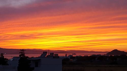 a sunset over a city with the sky at Dimitra Studios in Kastraki Naxou