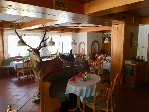 a restaurant with a deer head in the middle of a room at Landhotel Alte Aue in Altenau