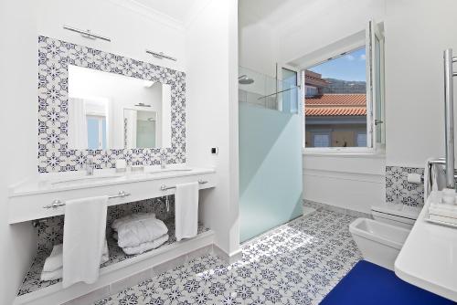 a bathroom with a mirror and a toilet at Hotel Villa Garden in Sant'Agnello