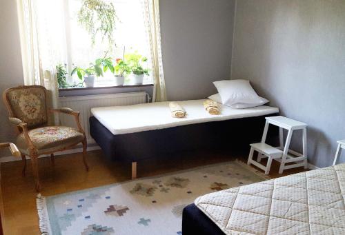 a bedroom with a bed and a chair and a window at Hus i Visby in Visby