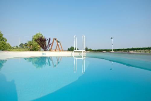 una gran piscina de agua azul con una grúa en el fondo en Agriturismo Albarello, en Sona