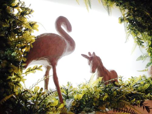 two ostriches and a baby giraffe standing in trees at GOIN Old House & Bar in Tainan