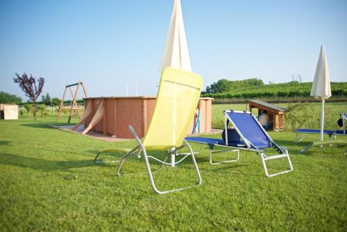 two lawn chairs and a playground in a park at Agriturismo Albarello in Sona