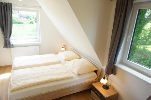 a small bed in a room with a window at Ferienhaus Tüxen in Hasselberg