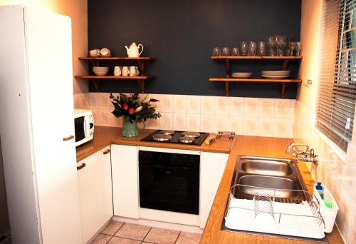 a kitchen with a sink and a stove at Villa De Vie Self Catering Apartment in Brackenfell