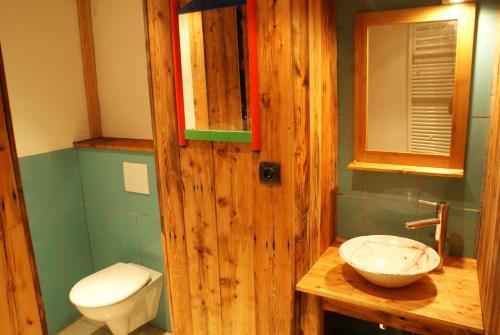 a bathroom with a wooden door and a sink at Le Berger Gourmand in Saint-Véran