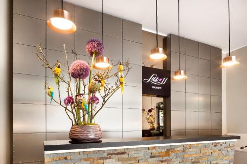 a lobby with a vase with flowers and birds at Lux 11 Berlin-Mitte in Berlin