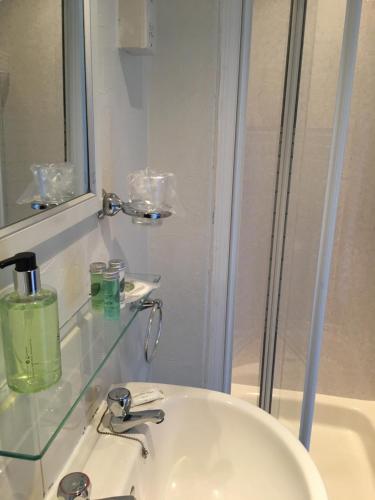 a bathroom with a sink and a glass counter at Melbourne Guest House in Bowness-on-Windermere