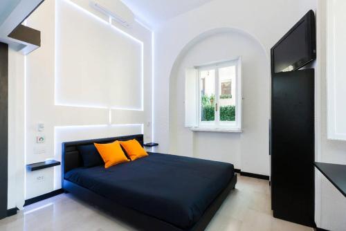 a bedroom with a blue bed with two orange pillows at LUX- Spanish Steps 60A Exclusive Suite Apartment in Rome