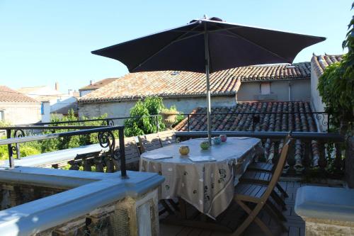a table with an umbrella on a balcony at Maison de maître à BRAM # Jacuzzi in Bram