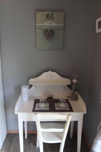 a white table with two chairs and a table with two glasses at Du Coté de Lacoume in Anla