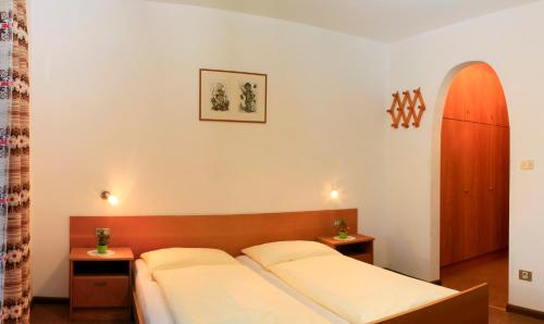 a bedroom with a bed with two white pillows at Pension Rastnerhof in Luson