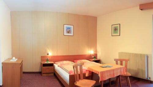 um quarto com uma cama e uma mesa e uma mesa e cadeiras em Pension Rastnerhof em Luson
