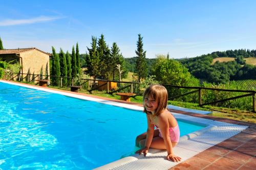 een klein meisje aan de rand van een zwembad bij RoccaiaCasa'70 in San Gimignano