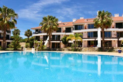 a large swimming pool in front of a building at Birdsong Vila Sol Village in Vilamoura