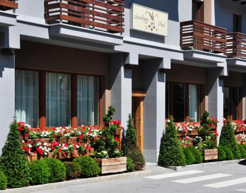 a building with flowers on the side of it at Serendipity Hotel in Sauze dʼOulx