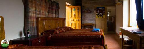 a bedroom with a bed and a table in a room at Casa Hotel Loma Wasi en Cotacachi in Cotacachi