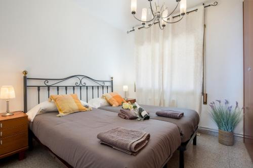1 dormitorio con 2 camas con almohadas y lámpara de araña en Matarolux 9, en Mataró