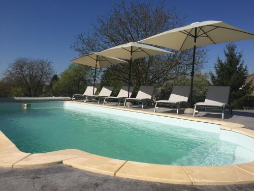 uma piscina com cadeiras e guarda-sóis em Bienvenue A La Campagne em Villers-sur-Port