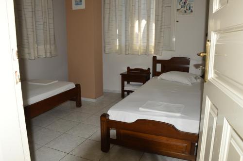 a room with two beds and two chairs in it at Manto Apartments in Tinos Town