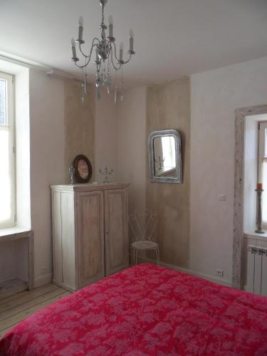 - une chambre avec un lit rouge et un lustre dans l'établissement La maison de Lilou, à Malbuisson