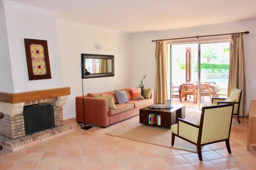 sala de estar con sofá y chimenea en Luxury T2 in Vila Sol Village en Vilamoura