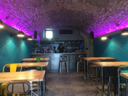 a bar with wooden tables and purple lighting at Hôtel de la Plage Les Arcades in Algajola