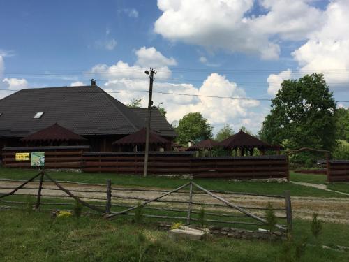 a barn with a wooden fence in front of it at Tsisarske Urochyshe in Rozgirche