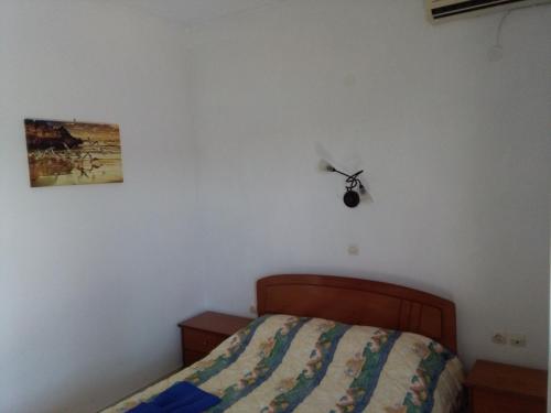 a bedroom with a bed with a ceiling fan on the wall at Thea Studios in Kalamakia