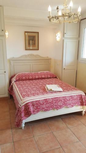 um quarto com uma cama grande e um cobertor vermelho em Résidence Le Home em Calvi