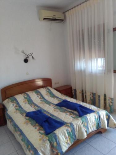 a bedroom with a bed with blue sheets and a window at Thea Studios in Kalamakia