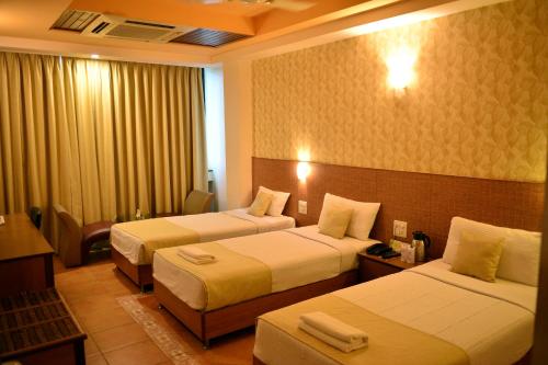 Giường trong phòng chung tại Goa Woodlands Hotel