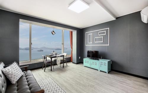 a living room with a couch and a table at Yeosu Blooming Pension in Yeosu