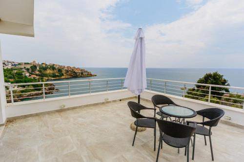 een balkon met een tafel en stoelen en de oceaan bij Teuta Apartments in Ulcinj