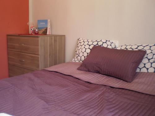 ガンディアにあるApartamento Cardenal Cisnerosのベッドルーム(紫色のベッド1台、ドレッサー付)