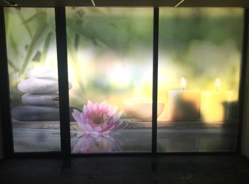 a pink flower sitting in front of candles at Fletcher Hotel-Restaurant de Wageningsche Berg in Wageningen