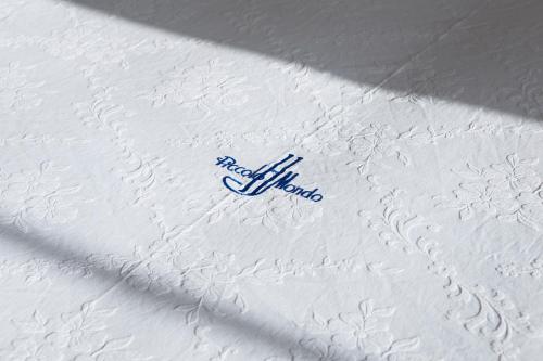 a white comforter with a philips logo on it at Hotel Piccolo Mondo in Castro di Lecce