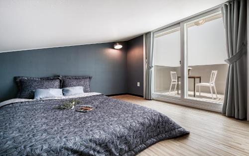 a bedroom with a large bed and a large window at Yeosu Blooming Pension in Yeosu