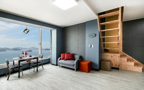 a room with a table and a chair and a window at Yeosu Blooming Pension in Yeosu