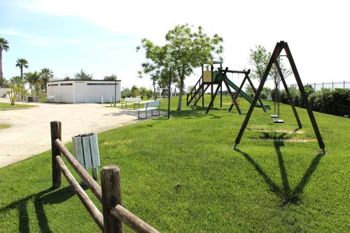a park with a swing set in the grass at Regiohotel Manfredi in Manfredonia
