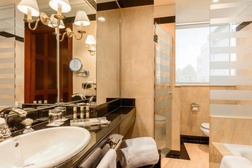 y baño con lavabo y ducha. en Eurostars Gran Hotel Santiago en Santiago de Compostela