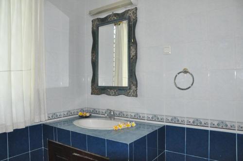 a bathroom with a sink and a mirror at Pondok Bali Sea View Bungalow in Lovina