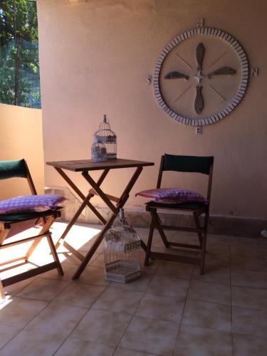 斯廷蒂諾的住宿－Villino Rosa，桌子和两把椅子,墙上的时钟