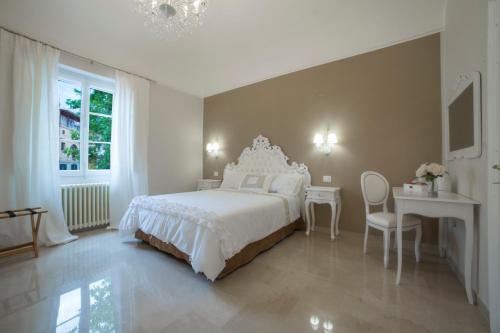a white bedroom with a bed and a table and chair at c'è posto per te in Vasto