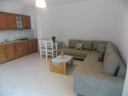 ein Wohnzimmer mit einem Sofa und einem Tisch in der Unterkunft Violet's Boutique Apartments in Sarandë