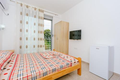 a bedroom with a bed and a large window at Teuta Apartments in Ulcinj