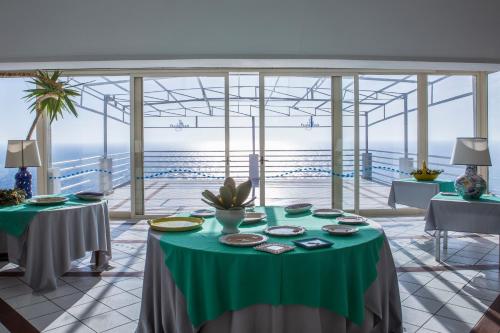 a dining room with a table with a green table cloth at Hotel Piccolo Mondo in Castro di Lecce