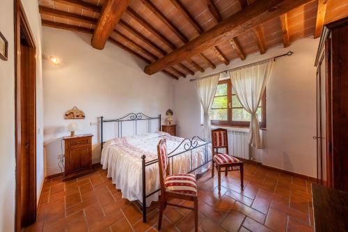 a bedroom with a bed and two chairs at Agriturismo Quercetelli in Castiglione del Lago